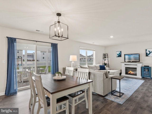 dining area featuring a notable chandelier and dark hardwood / wood-style flooring