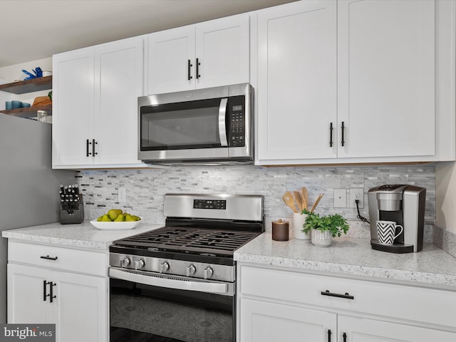 kitchen featuring appliances with stainless steel finishes, backsplash, and white cabinetry