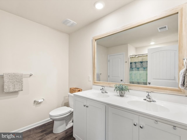 bathroom featuring walk in shower, hardwood / wood-style floors, vanity, and toilet