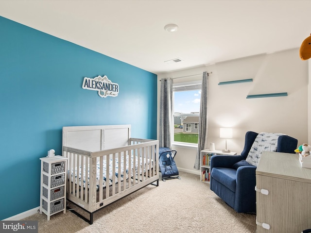 carpeted bedroom featuring a nursery area