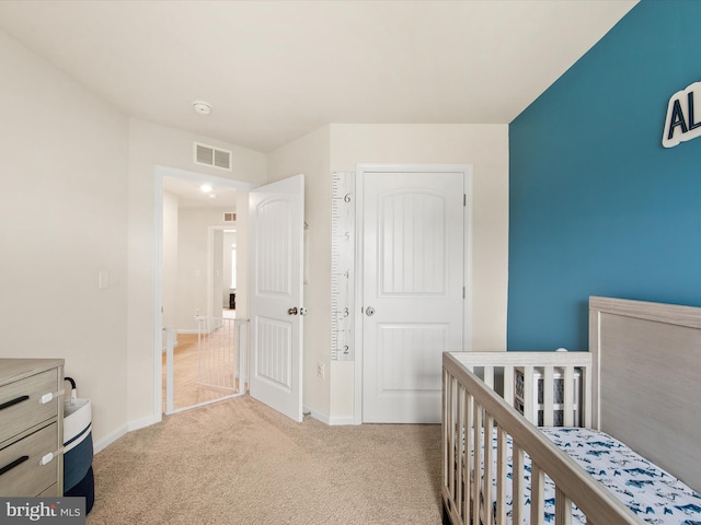 carpeted bedroom featuring a nursery area and a closet