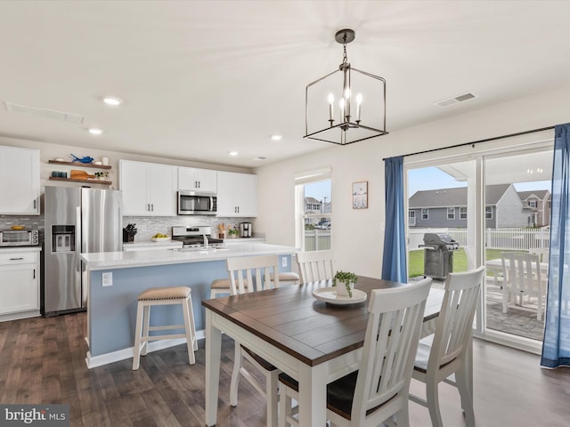 dining space featuring an inviting chandelier and dark hardwood / wood-style flooring