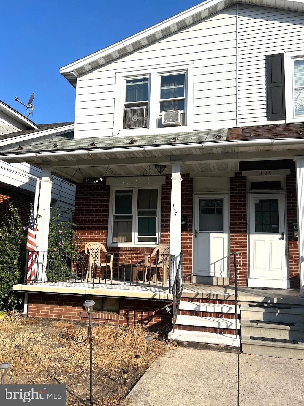 view of front facade with cooling unit and a porch