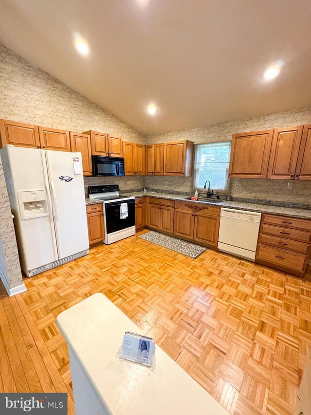 kitchen with sink, tasteful backsplash, white appliances, light parquet floors, and light stone countertops