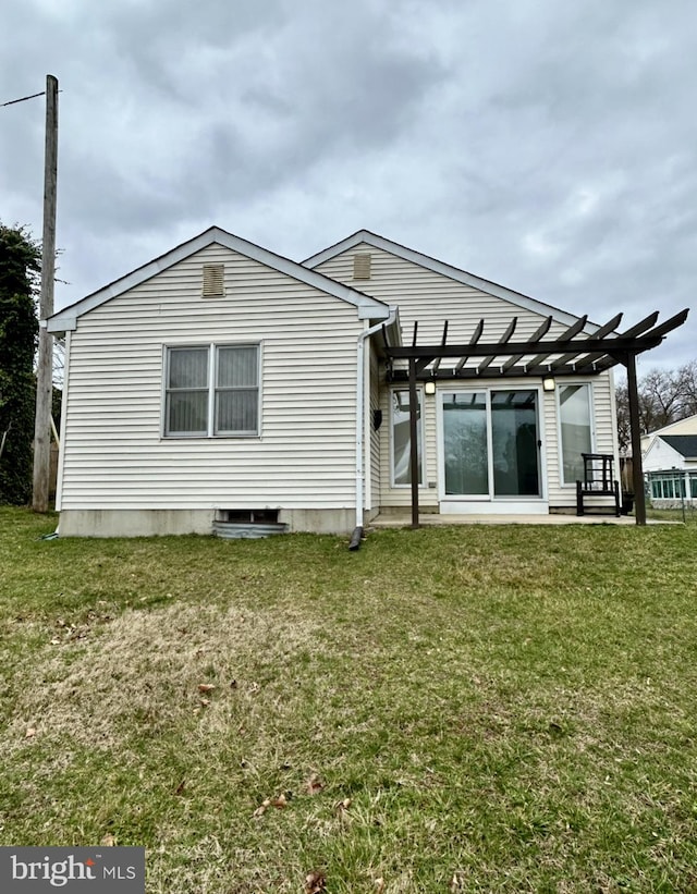 rear view of property featuring a pergola and a yard