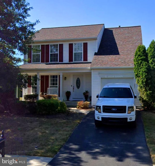 colonial-style house with a garage and covered porch