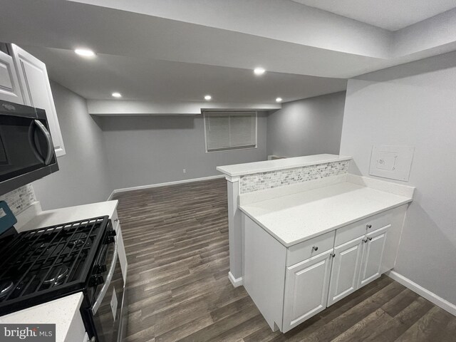 kitchen featuring kitchen peninsula, white cabinetry, dark wood-type flooring, and stainless steel appliances