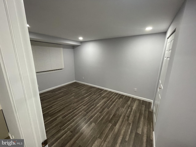 spare room featuring dark wood-style flooring, baseboards, and recessed lighting