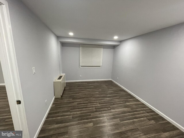 finished basement featuring radiator heating unit, recessed lighting, baseboards, and dark wood finished floors