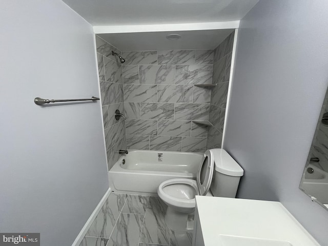 full bathroom featuring tiled shower / bath, vanity, and toilet