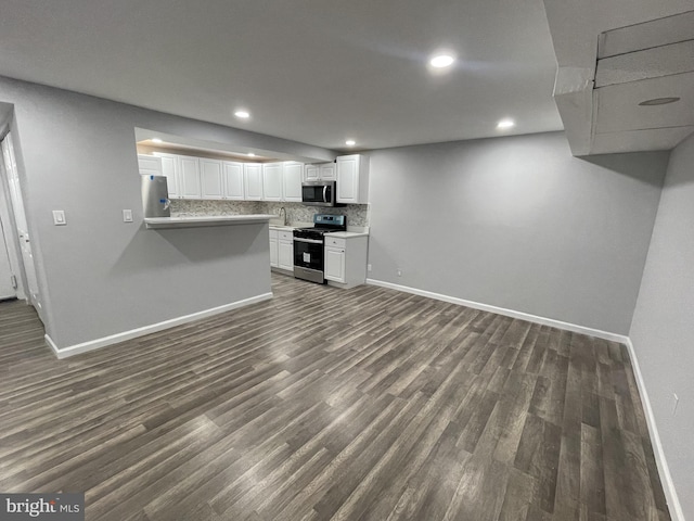kitchen featuring tasteful backsplash, appliances with stainless steel finishes, baseboards, and dark wood-type flooring