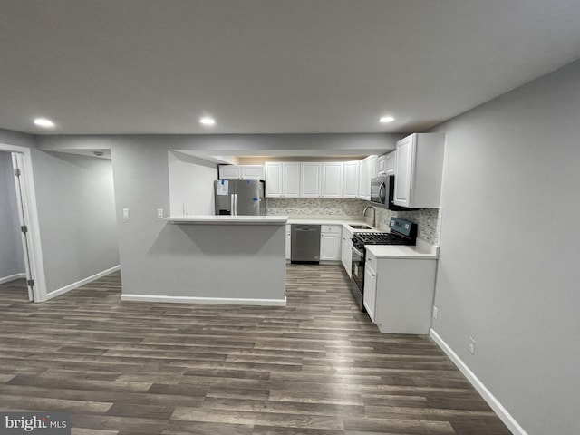 kitchen featuring stainless steel appliances, dark wood-type flooring, decorative backsplash, and white cabinetry