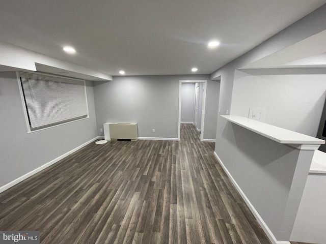 finished below grade area with baseboards, recessed lighting, and dark wood-style flooring