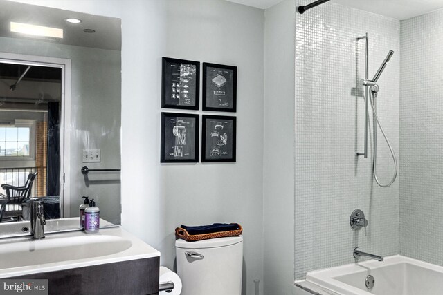 full bathroom featuring vanity, tiled shower / bath combo, and toilet