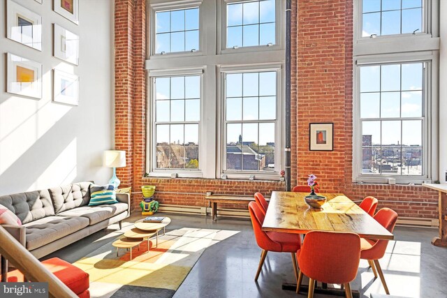 living room with brick wall, a towering ceiling, and a wealth of natural light