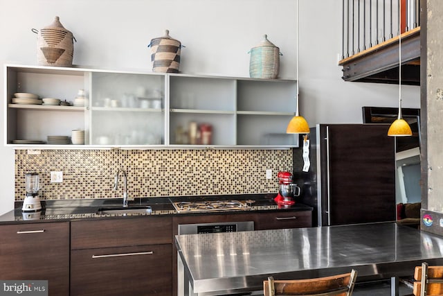 kitchen featuring pendant lighting, sink, tasteful backsplash, dark brown cabinets, and appliances with stainless steel finishes