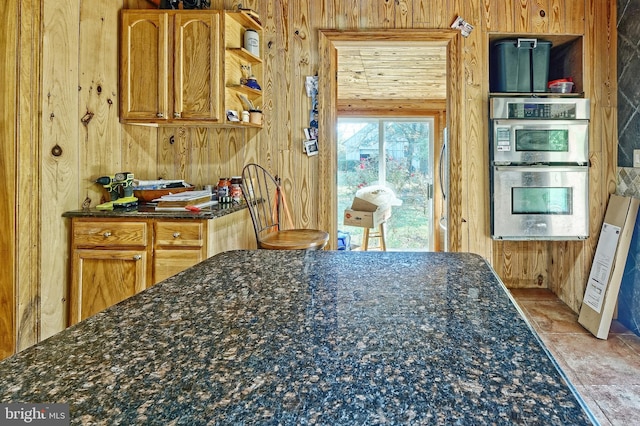 kitchen featuring wood walls and stainless steel double oven