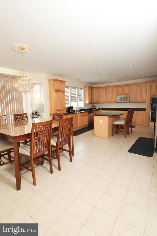 dining space featuring a chandelier, light tile patterned floors, and sink