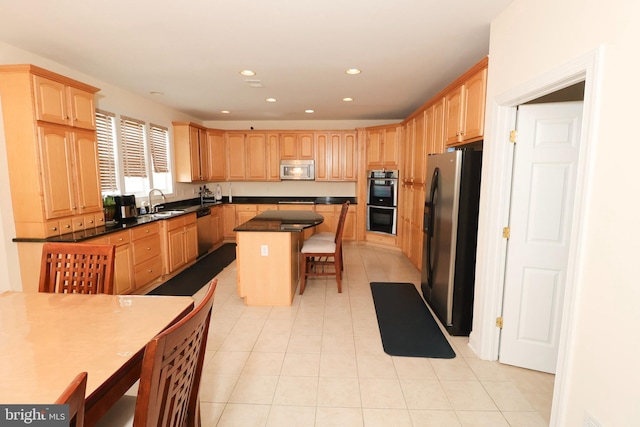 kitchen featuring appliances with stainless steel finishes, a breakfast bar area, light tile patterned floors, a center island, and sink