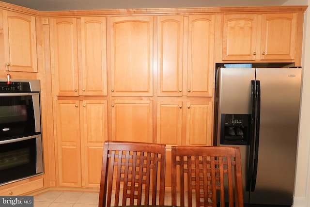 kitchen featuring light brown cabinets, stainless steel appliances, and light tile patterned floors