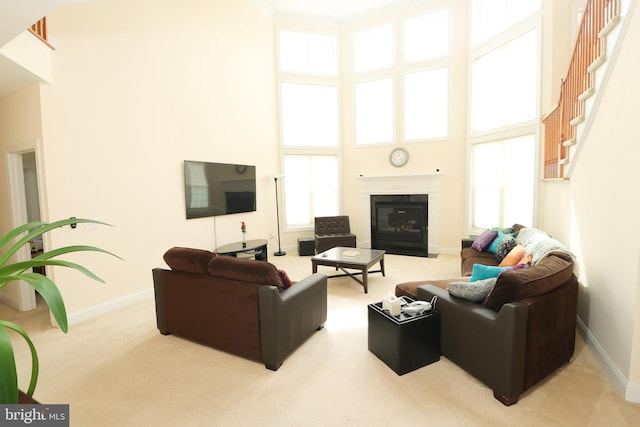 carpeted living room featuring a towering ceiling