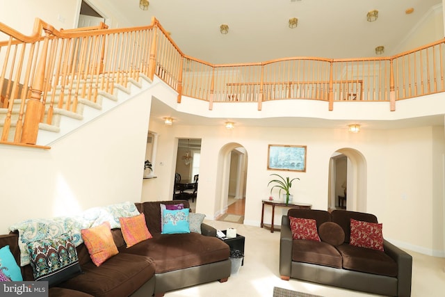 living room with a towering ceiling and carpet flooring