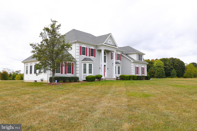 greek revival house featuring a front yard