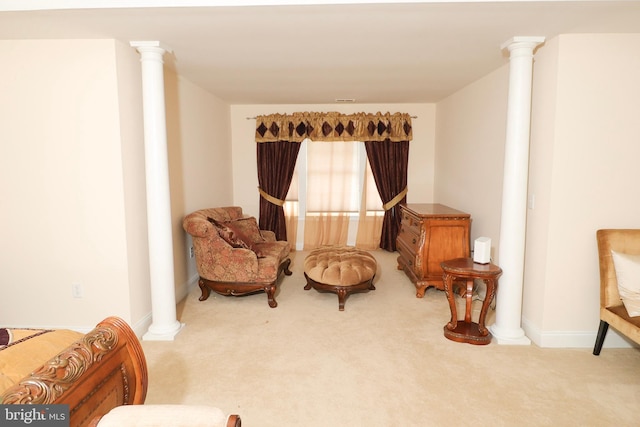 living area with carpet floors and ornate columns