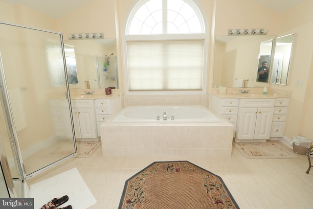 bathroom featuring plus walk in shower, tile patterned floors, vaulted ceiling, and vanity