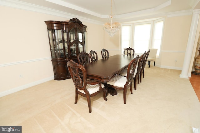 dining room featuring crown molding, decorative columns, and light carpet