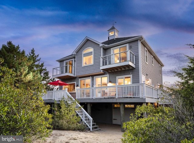 back house at dusk with a balcony