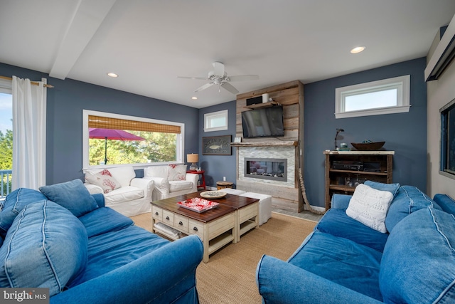 carpeted living room featuring a fireplace, beam ceiling, and ceiling fan