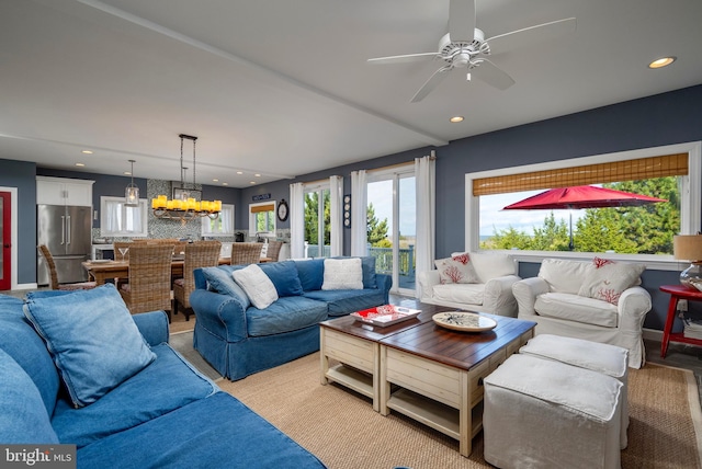 living room featuring ceiling fan with notable chandelier