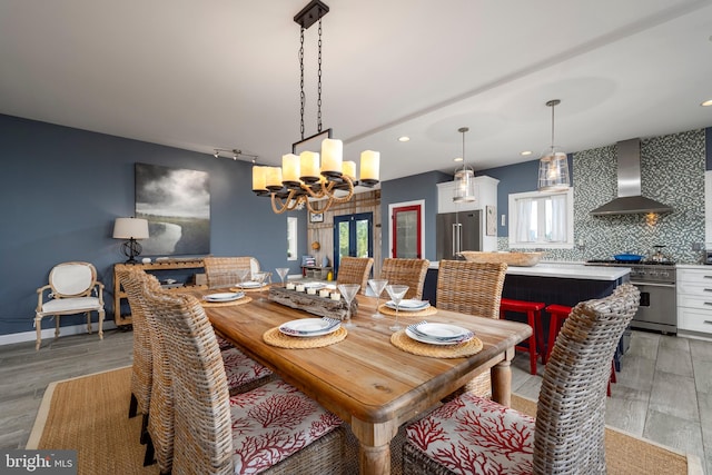 dining space with light hardwood / wood-style floors and an inviting chandelier