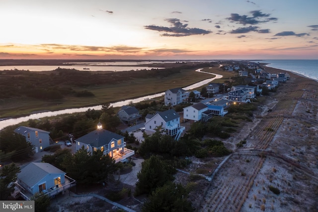 aerial view at dusk featuring a water view