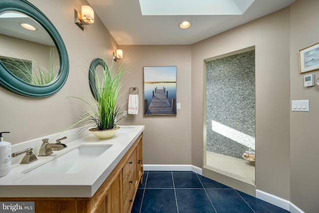 bathroom with vanity, a skylight, and tile patterned floors