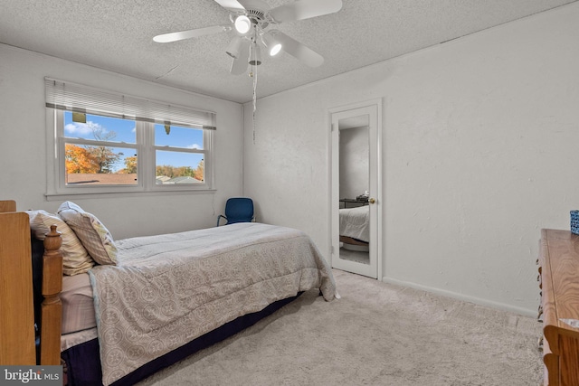 carpeted bedroom featuring a textured ceiling and ceiling fan