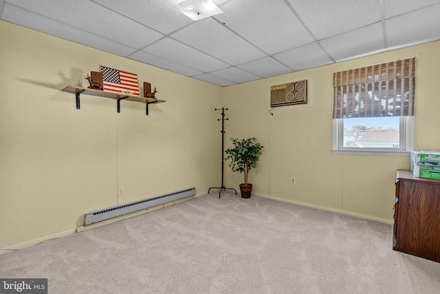 unfurnished room with light carpet, a baseboard radiator, a paneled ceiling, and a wall mounted air conditioner