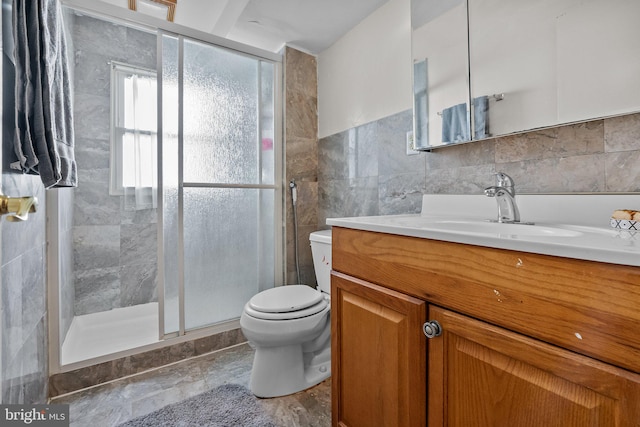 bathroom featuring vanity, toilet, tile walls, and an enclosed shower