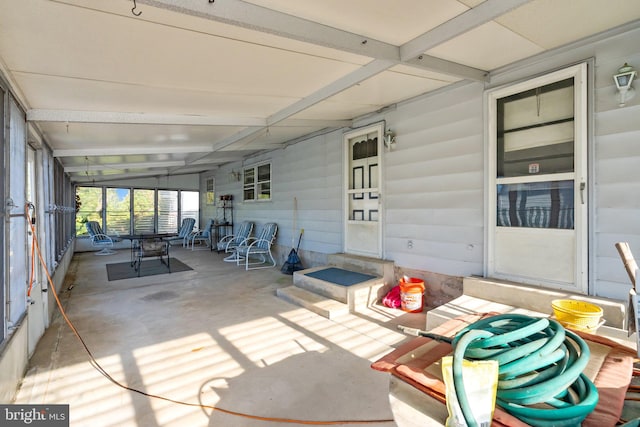 unfurnished sunroom featuring beam ceiling