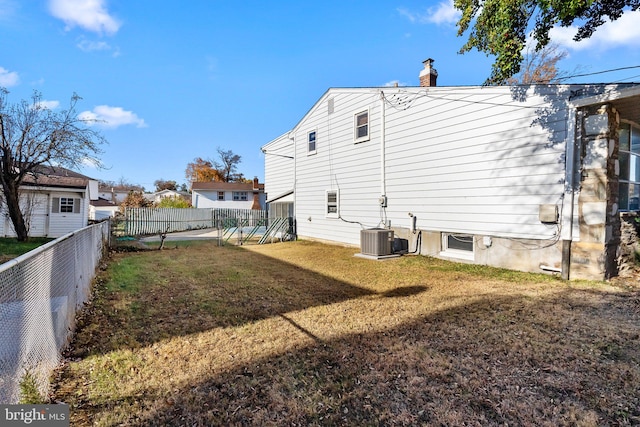 back of house with a yard and central AC unit