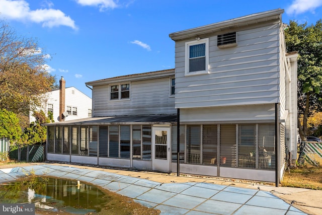 rear view of property featuring a sunroom