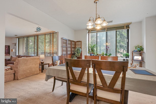 dining space featuring light hardwood / wood-style flooring, a chandelier, and plenty of natural light