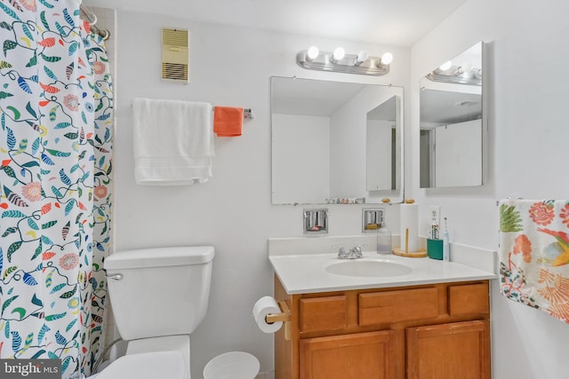 bathroom with walk in shower, vanity, and toilet