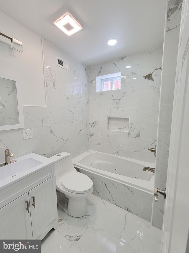 full bathroom featuring tiled shower / bath, vanity, and toilet