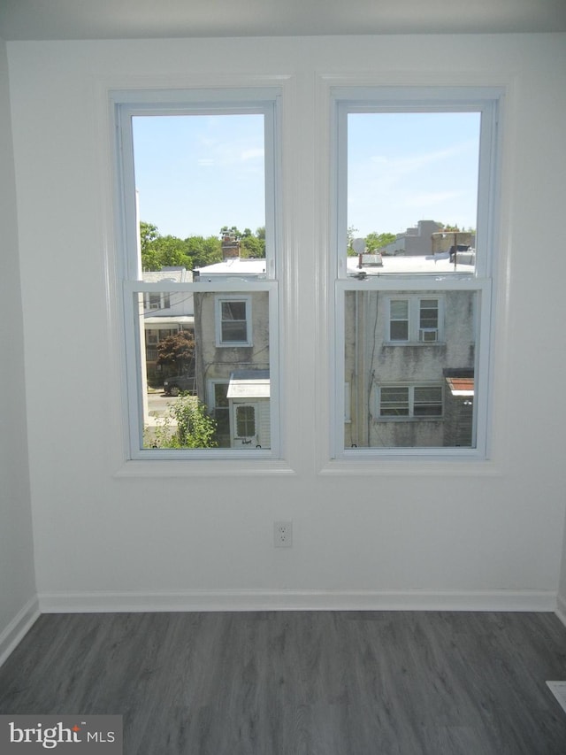 empty room featuring plenty of natural light and dark hardwood / wood-style floors