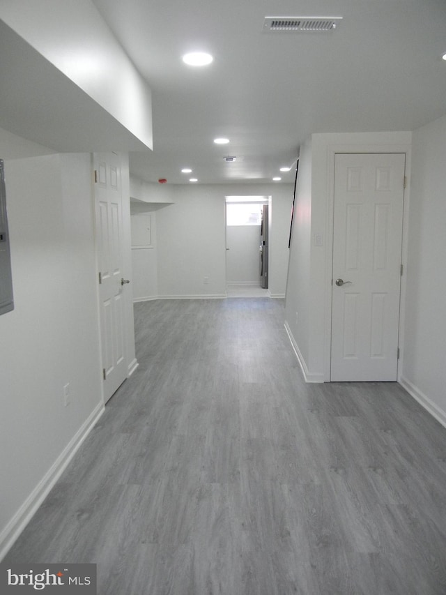 basement with light hardwood / wood-style flooring