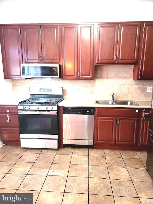 kitchen with decorative backsplash, sink, and stainless steel appliances