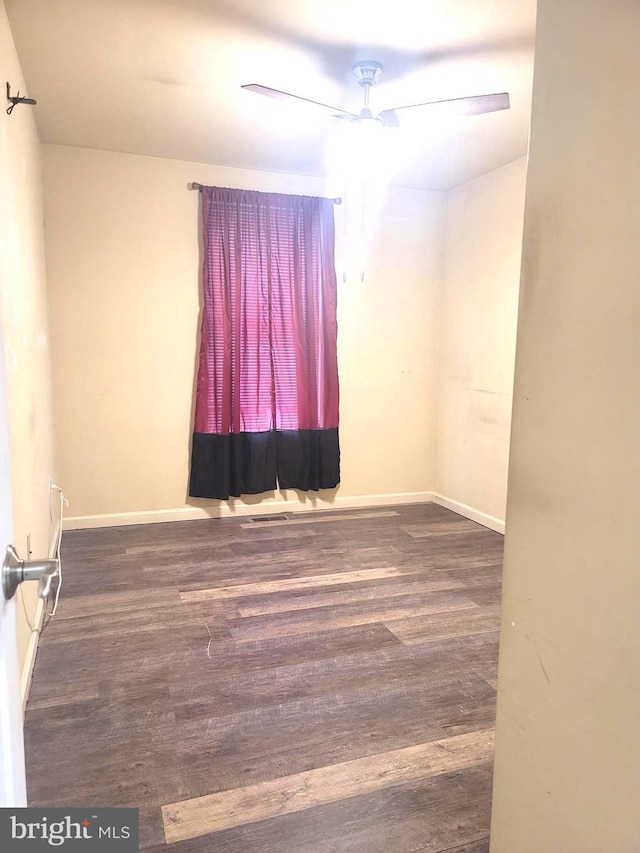 spare room with ceiling fan and dark hardwood / wood-style flooring