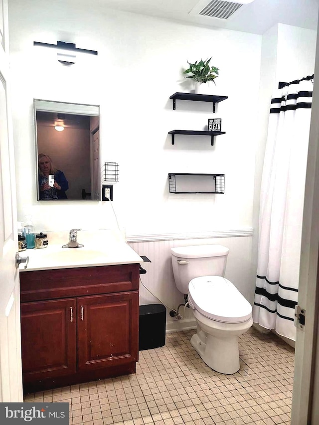 bathroom with tile patterned flooring, vanity, toilet, and a shower with shower curtain